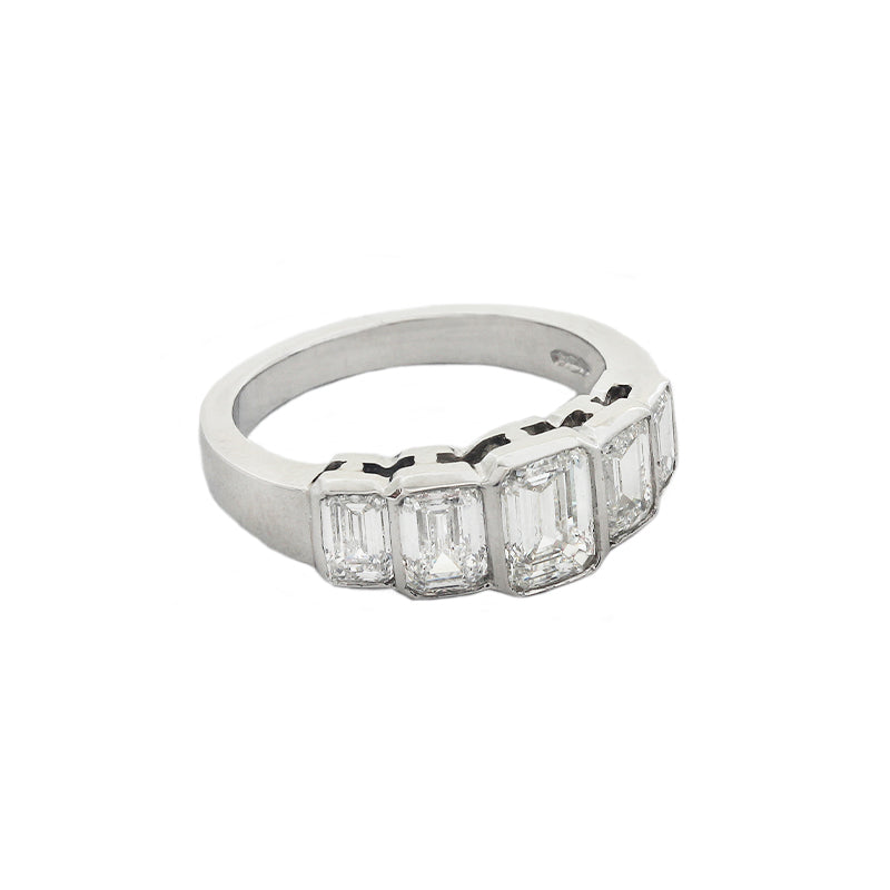 A five stone graduated diamond ring in platinum. Emerald cut Diamonds are rub over set in individual settings