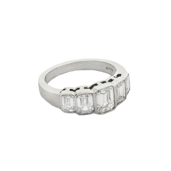 A five stone graduated diamond ring in platinum. Emerald cut Diamonds are rub over set in individual settings