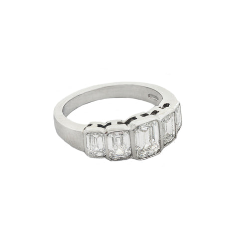 A five stone graduated diamond ring in platinum. Emerald cut Diamonds are rub over set in individual settings
