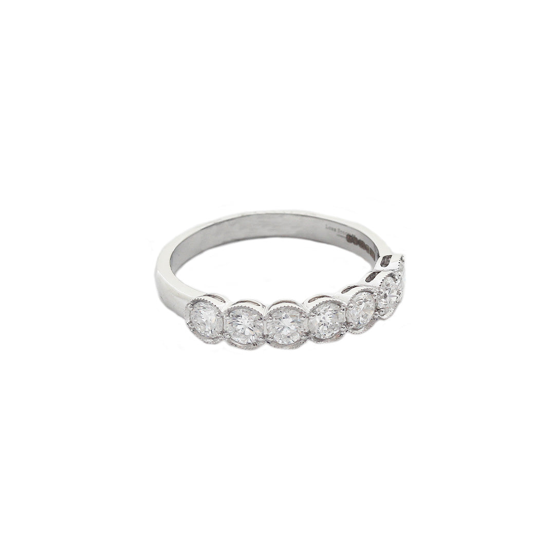 A seven stone Diamond Half Eternity Ring in 18ct White Gold. The diamonds are four claw set with an outer box setting with a millegrain edge