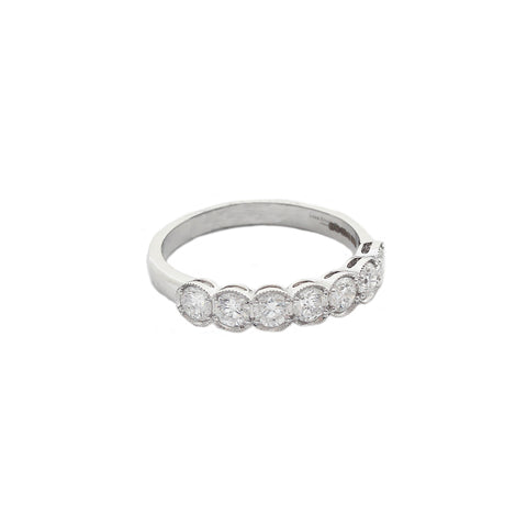 A seven stone Diamond Half Eternity Ring in 18ct White Gold. The diamonds are four claw set with an outer box setting with a millegrain edge