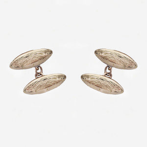 Pair of gold cufflinks on a light grey background