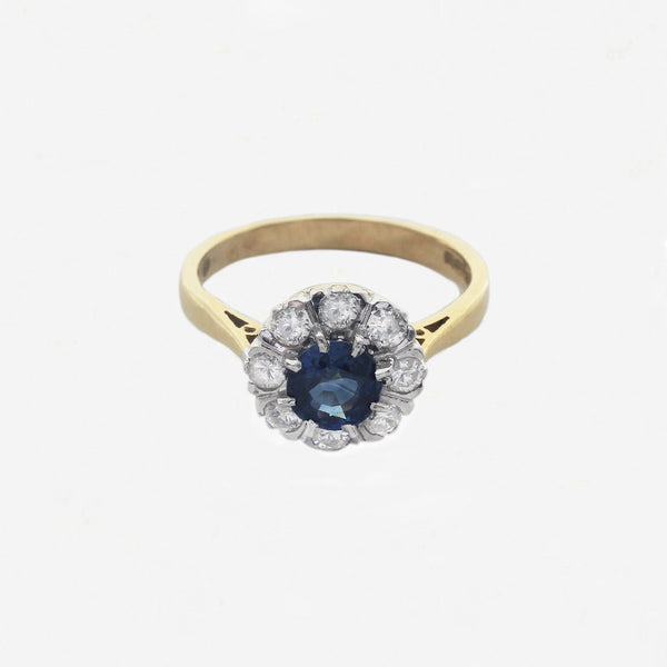 central round sapphire diamond surround yellow gold ring white background