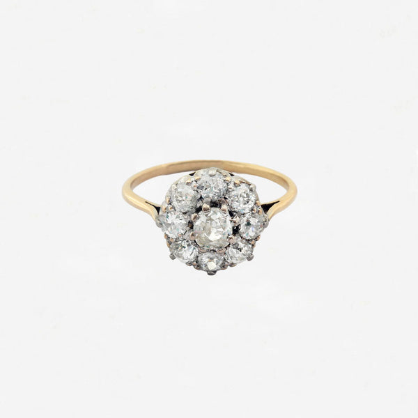Gold ring with diamond cluster on a white background