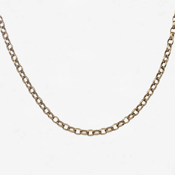 Gold chain necklace on a light grey background