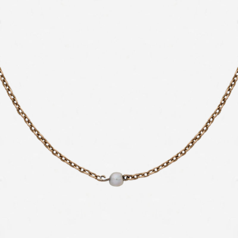 a yellow gold chain with single pearls