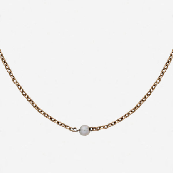 a yellow gold chain with single pearls