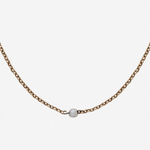 a yellow gold chain with single pearls