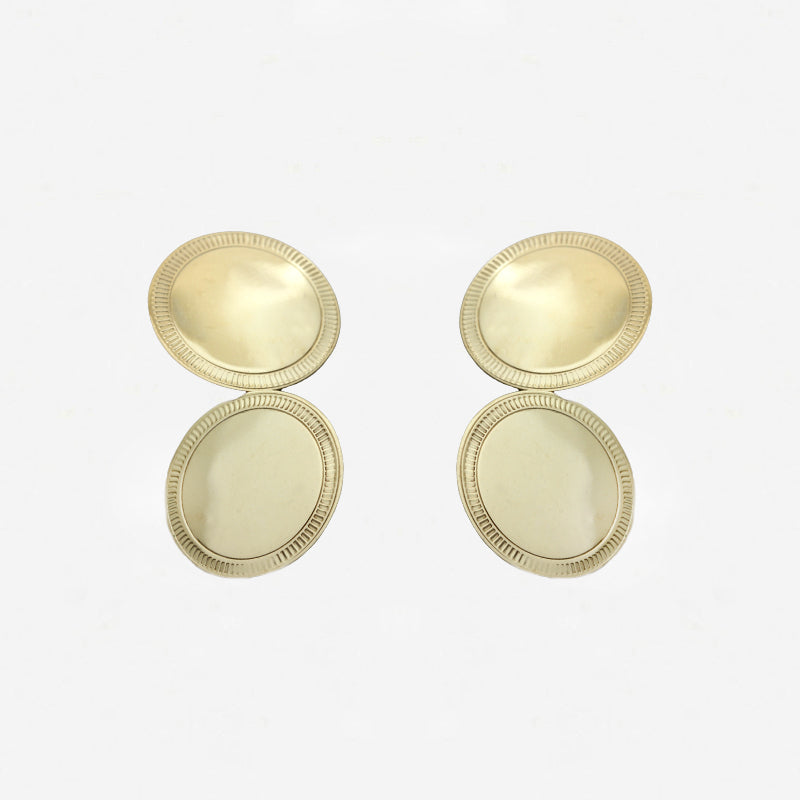 Pair of gold cufflinks on a light grey background