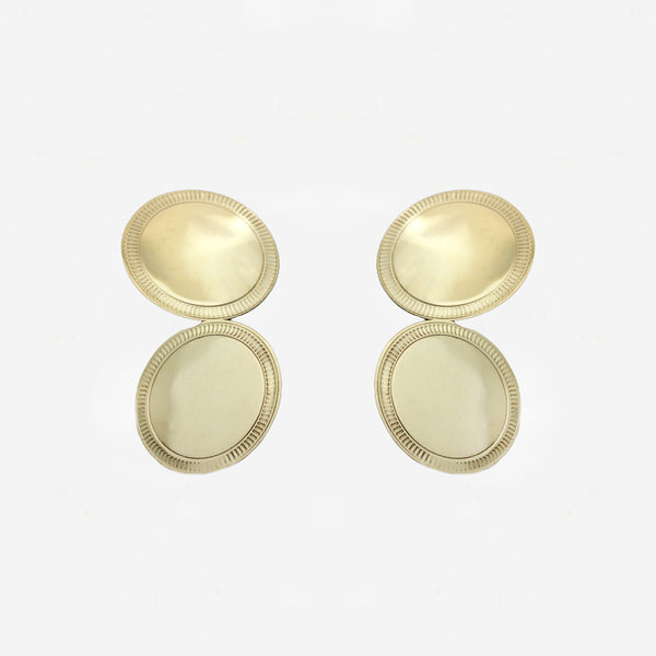 Pair of gold cufflinks on a light grey background