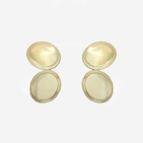Pair of gold cufflinks on a light grey background