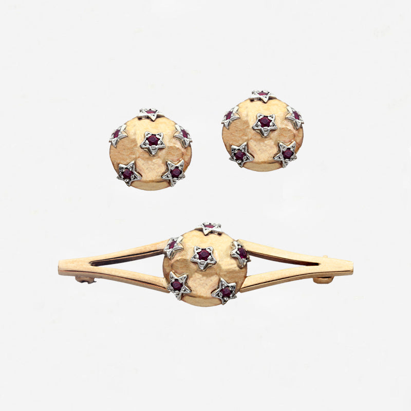 Gold jewelry set with round designs and gemstones on a white background