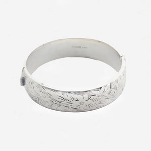 Silver headband with floral engravings on a white background