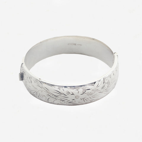 Silver headband with floral engravings on a white background