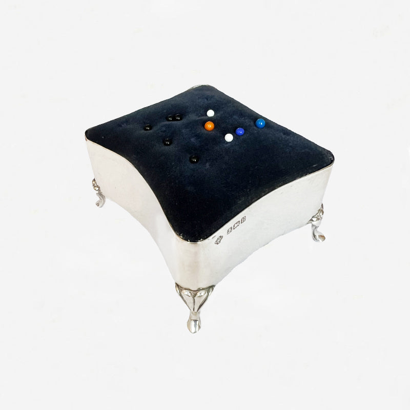 silver pin cushion with blue velvet top and plain silver base and legs
