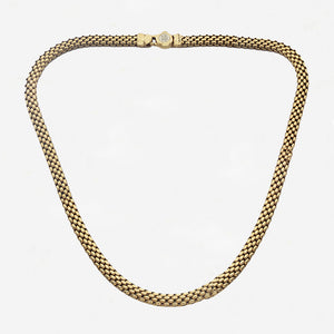 Gold chain necklace on a light grey background