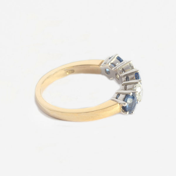a yellow and white gold 5 stone ring with sapphires and diamonds claw set