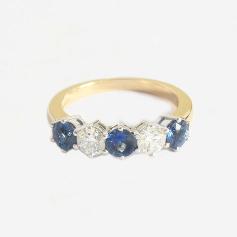 a sapphire and diamond 5 stone ring with claw settings and white and yellow gold