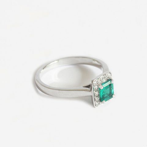 a stunning emerald and diamond square shaped cluster ring in white gold