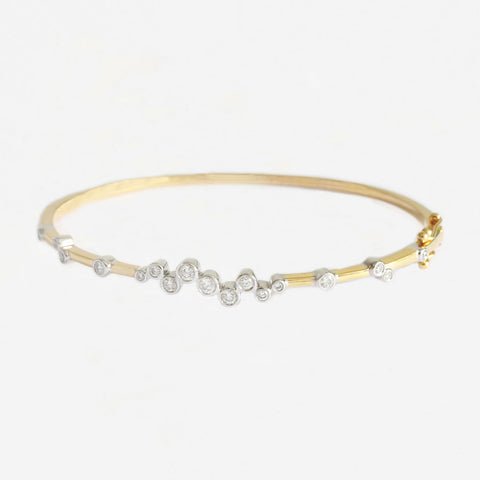 a contemporary diamond white and yellow gold hinged oval bangle