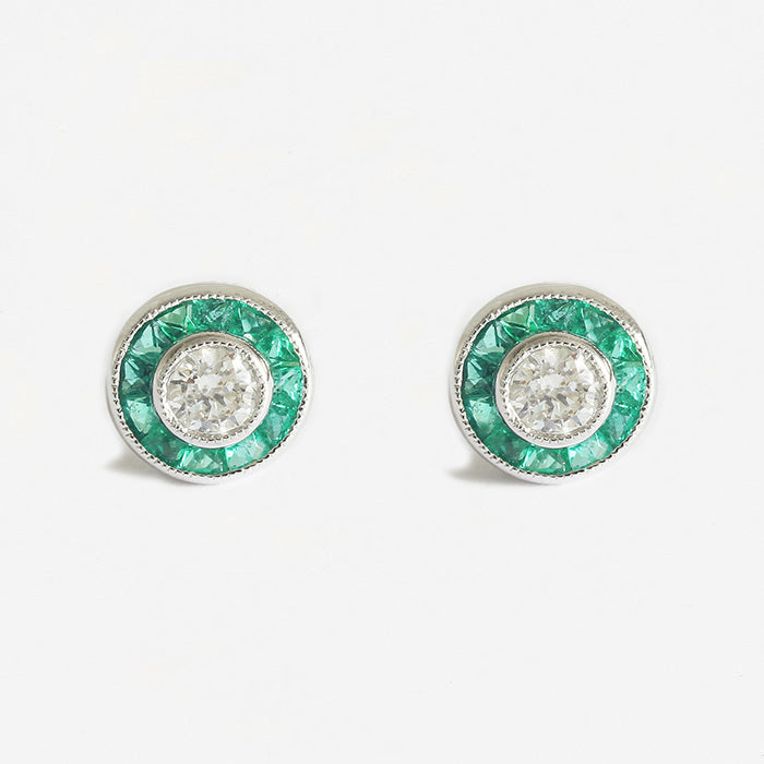 a stunning pair of emerald and diamond round cluster stud earrings in white gold