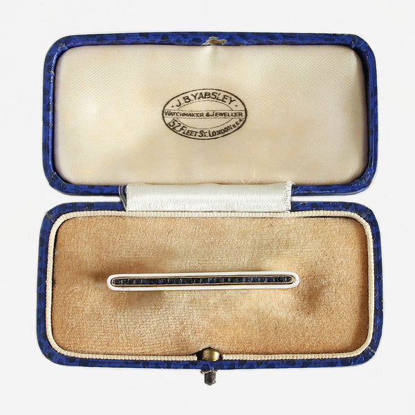 a sapphire and white enamel bar brooch in 18 carat gold