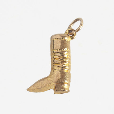a yellow gold riding boot charm with grooved pattern 
