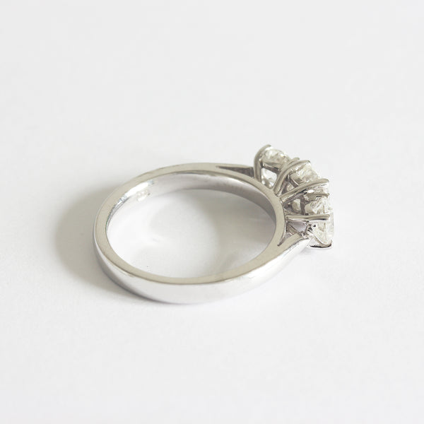 Side view of a three stone Diamond ring in white gold. The graduated round diamonds are four claw set