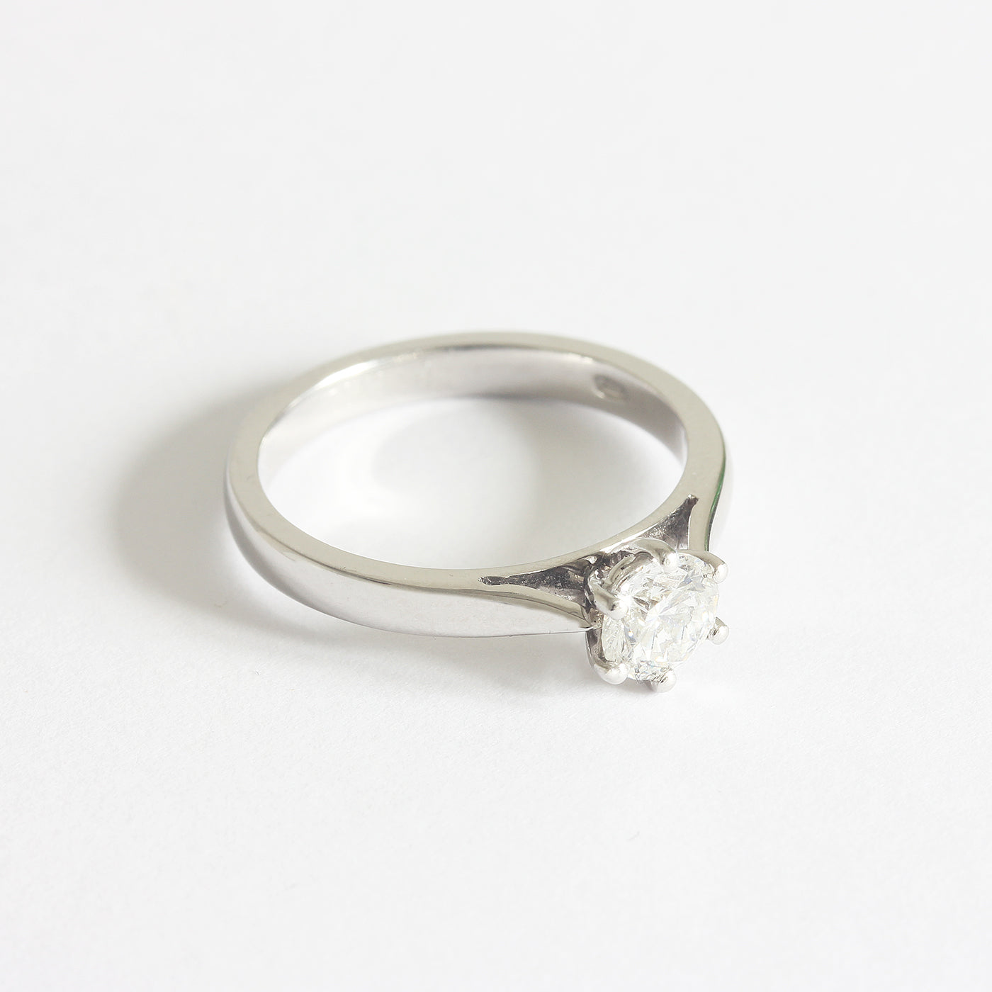 A solitaire modern brilliant cut diamond ring in platinum. The diamond is six claw set 