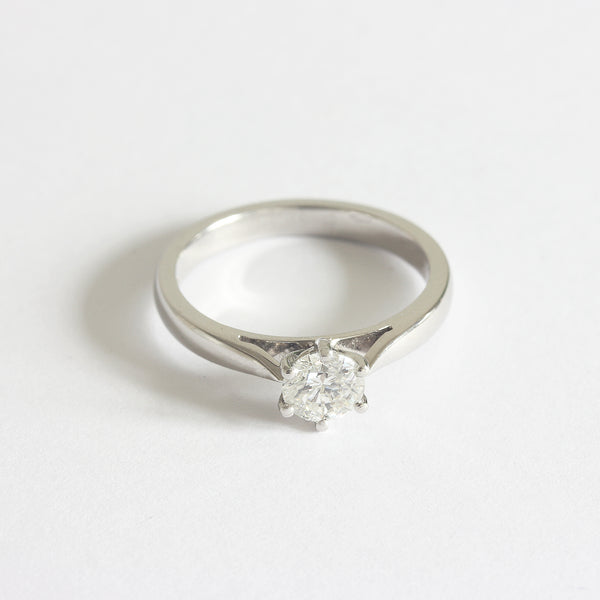 Front view of a solitaire modern brilliant cut diamond ring in platinum. The diamond is six claw set 