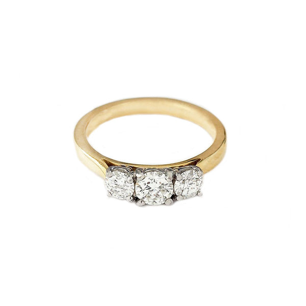 Front view of a three stone brilliant cut diamond ring in yellow gold. The diamonds are four claw set in white gold