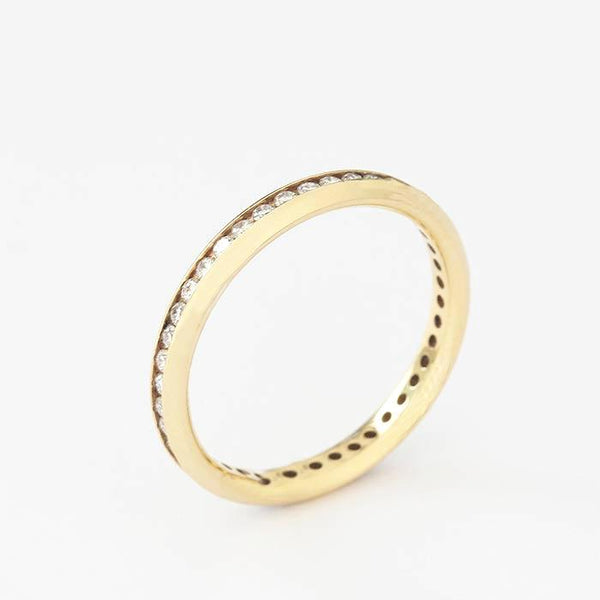an 18ct yellow gold diamond set full eternity ring with round stones in a channel setting