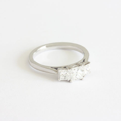A three stone princess cut diamond ring in platinum. The square diamonds are four claw set.