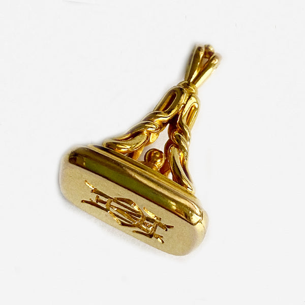 a vintage secondhand yellow gold fob charm with entwined initials dated 1911