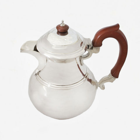 a plain silver water jug with wooden handle dated 1931