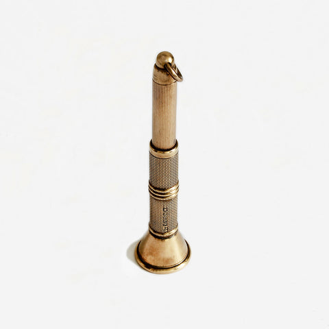 a yellow gold cigar piercer with engine turned finish and hallmark