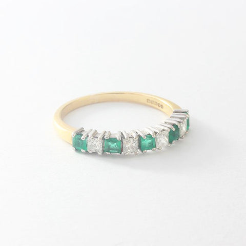 an emerald diamond claw set half eternity ring in gold