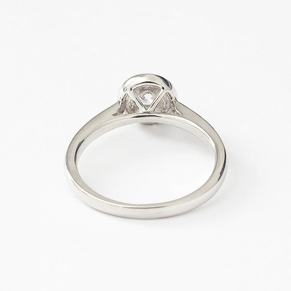 Back view of a Diamond cluster ring in platinum. There is a single round diamond to centre in a raised four claw setting surrounded by smaller diamonds