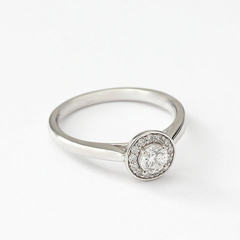 A Diamond cluster ring in platinum. There is a single round diamond to centre in a raised four claw setting surrounded by smaller diamonds