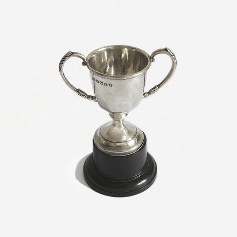 a small silver vintage trophy cup and plinth dated 1934