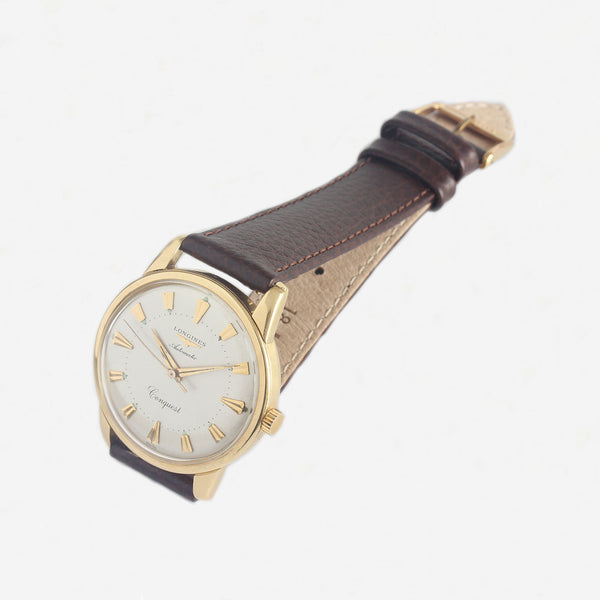 a 1950s mens longings watch with gold case and leather strap