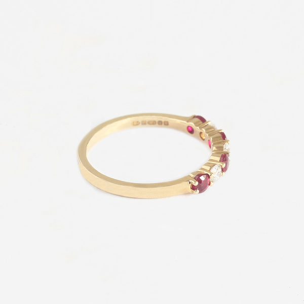 a ruby and diamond claw set eternity ring in yellow gold