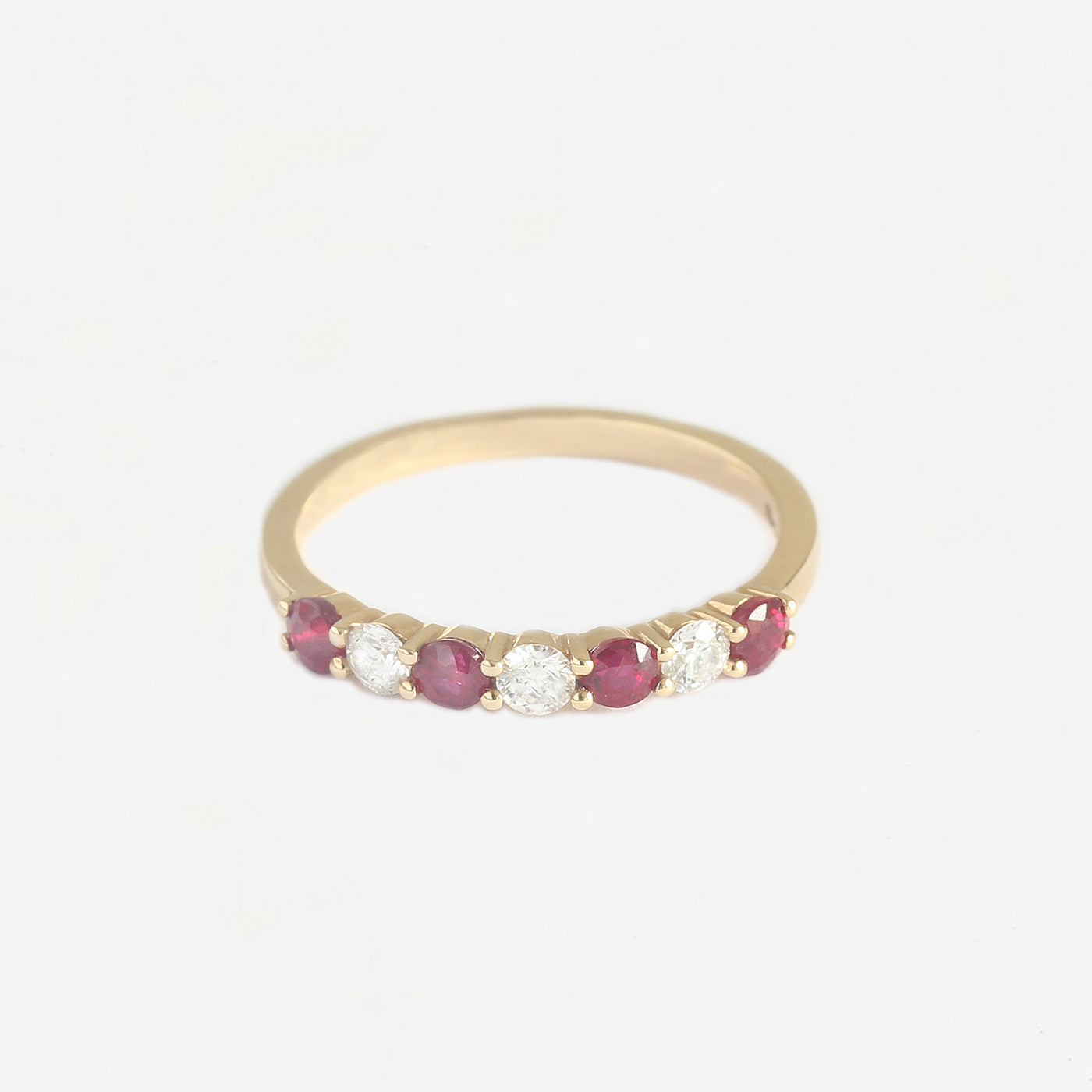 a yellow gold ruby diamond half eternity ring