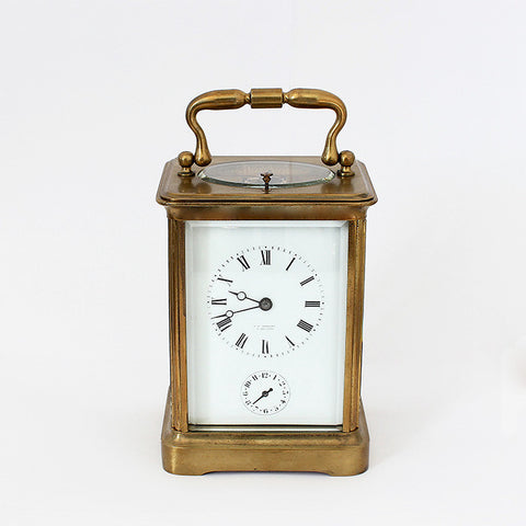 antique carriage clock with a brass case and white dial