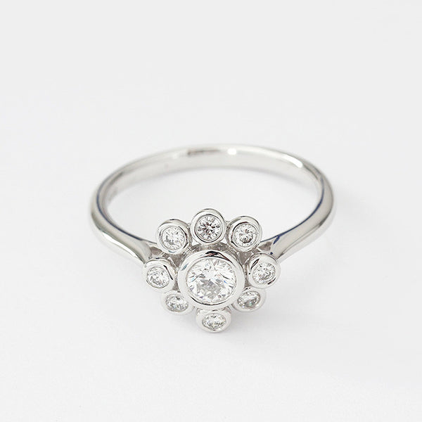 18ct white gold diamond cluster ring in a flower shape and rubover setting