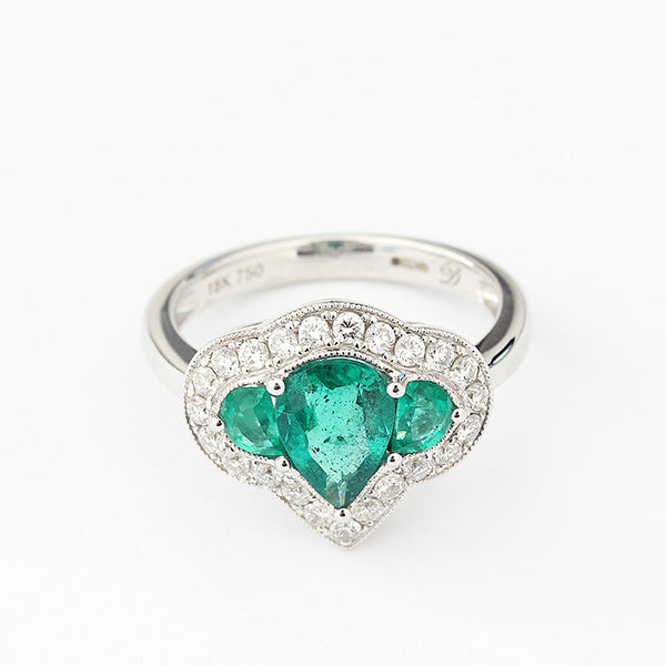a modern cluster ring with emeralds and diamonds in a claw setting white gold