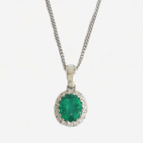 an emerald and diamond claw set oval cluster pendant necklace in white gold