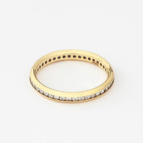 an 18ct yellow gold full eternity ring 2mm wide with small round diamonds in a channel