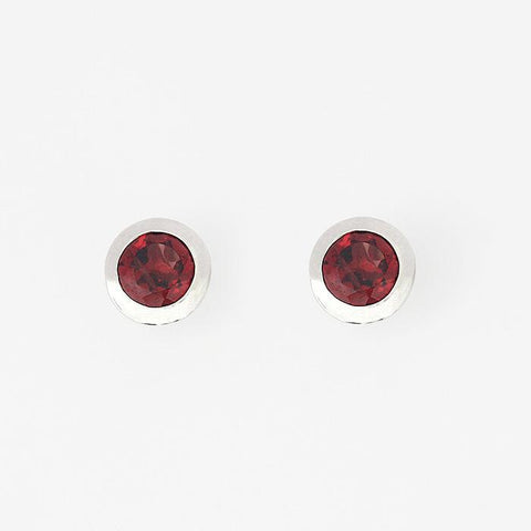 round garnet stud earrings in silver with a rub over setting