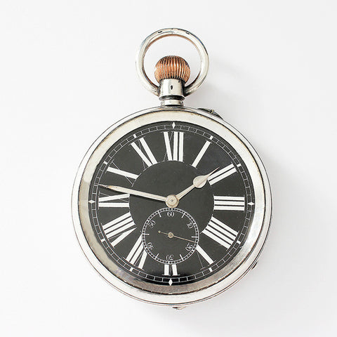 a large silver vintage pocket watch with engraving on the inside